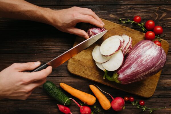 Colorful vegetables being sliced for a fresh, homemade meal.